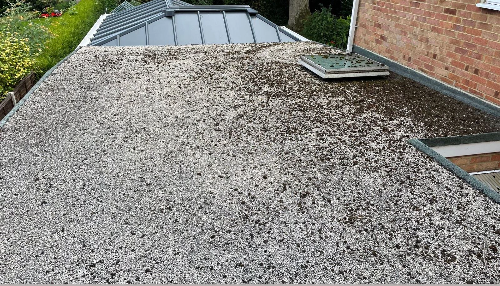 Flat garage roof with moss growth and weathered surface