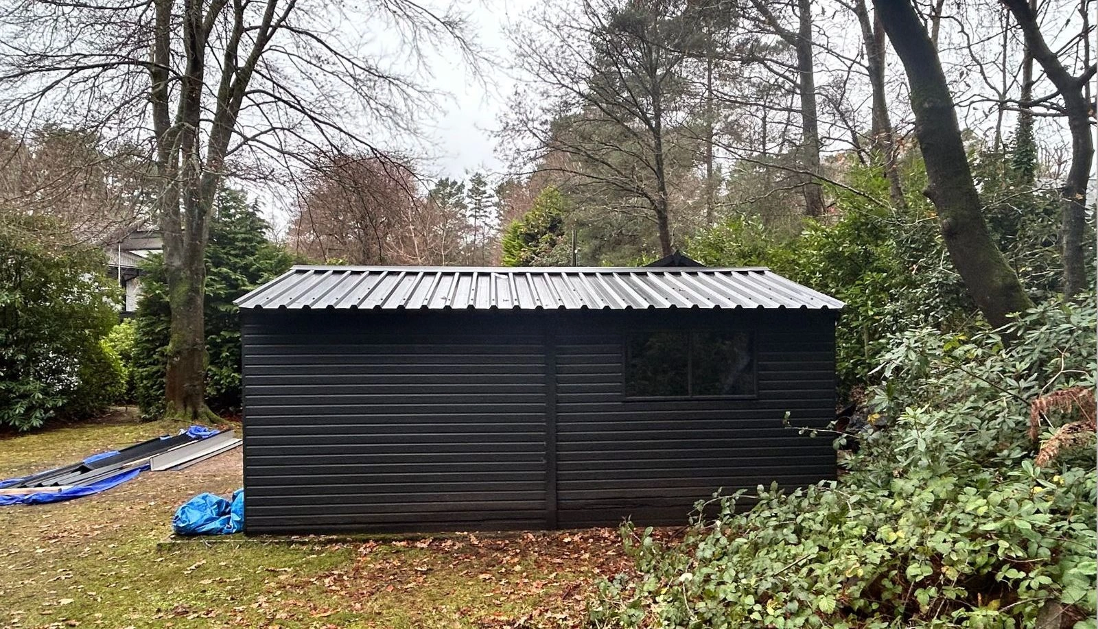 Garden outbuilding with new black corrugated metal roof